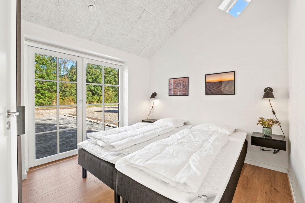 Soveværelse med dobbeltseng og grønt gardin