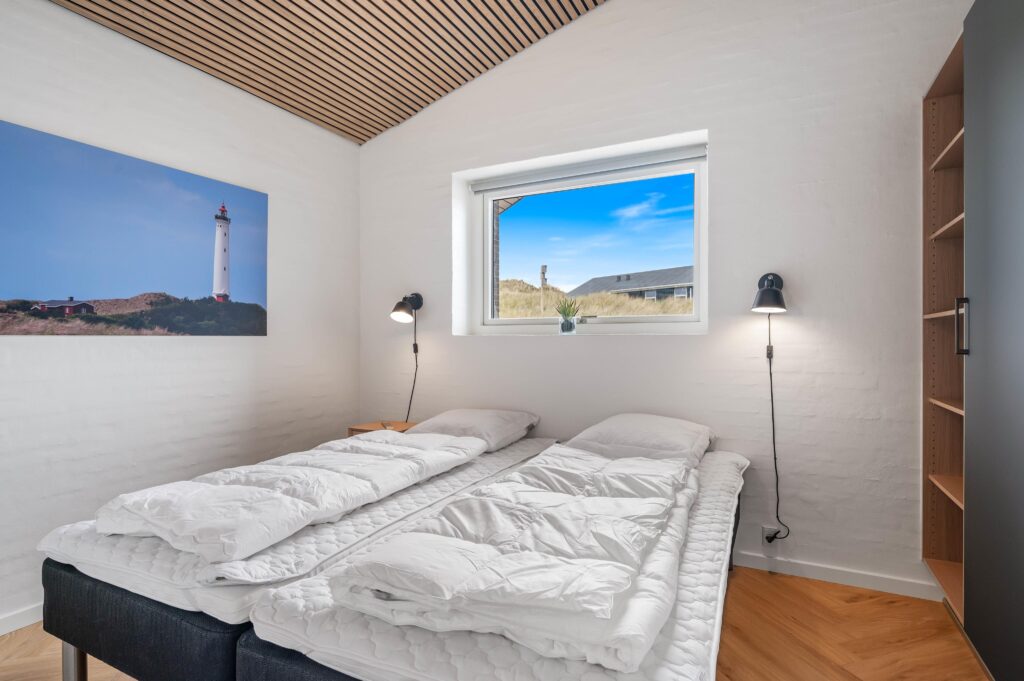 Soveværelse med enkelt seng og væglampe