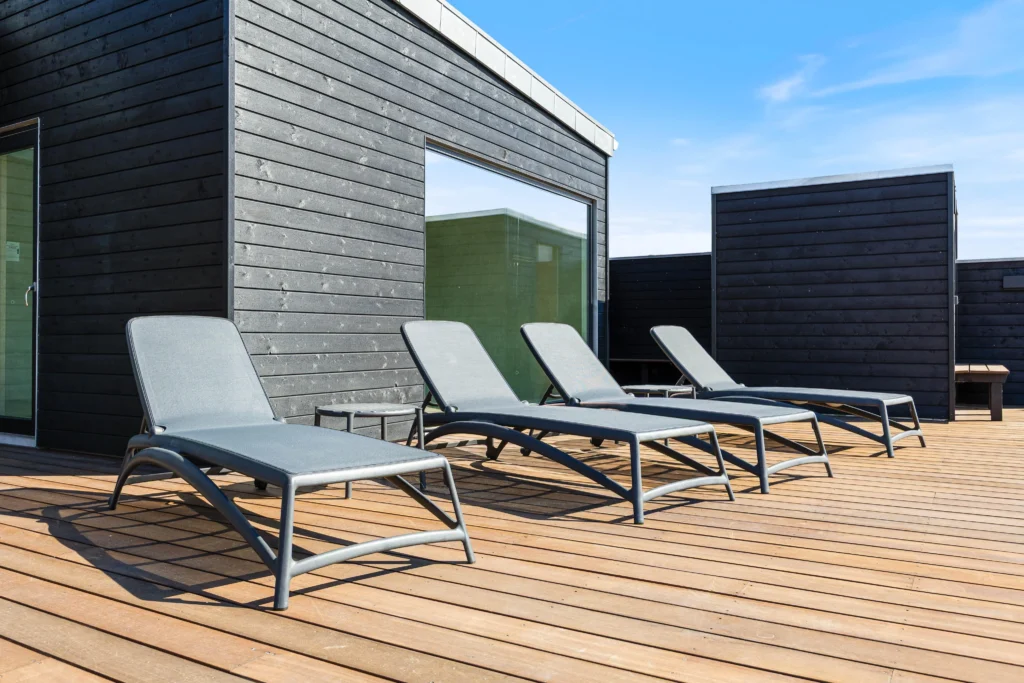 Soveværelse med dobbeltseng og blågrå accentvæg i sommerhus i Bjerregård