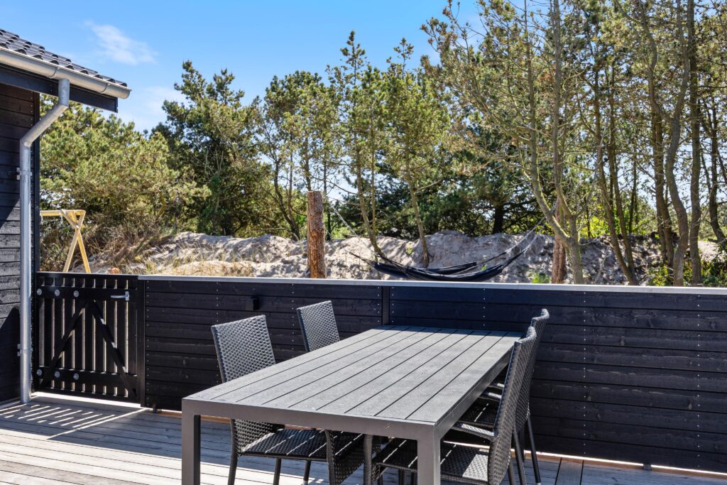 Åben plan med langt spisebord og stole set fra den modsatte side mod stuen