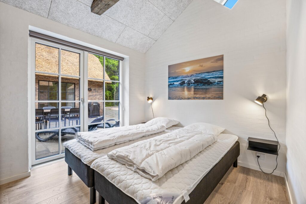 Soverum med dobbeltseng og terrassedør i sommerhus i Vester Husby